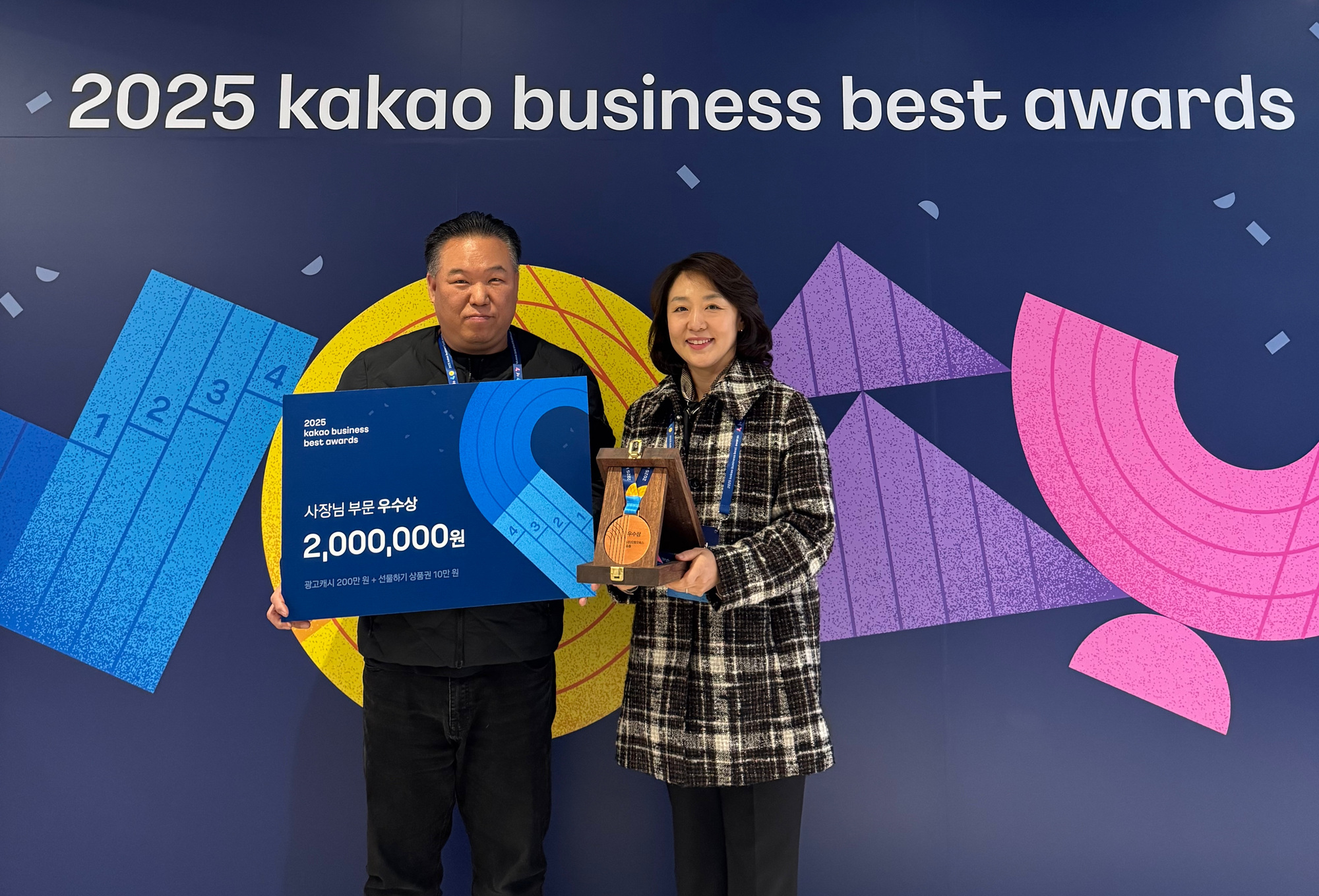2025 카카오비즈니스 베스트 어워즈 행사장에서 상패와 사장님 부문 우수상 보드를 들고 촬영한 수상 기념 사진